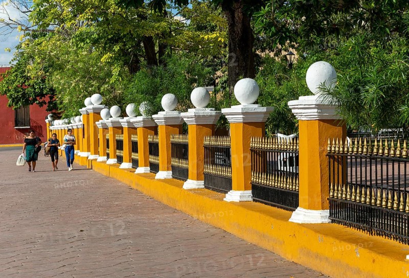 Three women walking along side of main zocalo park in city centre, Valladolid, Yucatan, Mexico, Central America