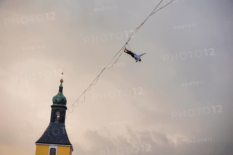 Highline and family festival in Hohnstein Highlines are stretched over the roofs of Hohnstein and between sandstone rocks, over which daring extreme athletes balance. Ruben Langer impresses with tricks on a highline from the church tower to Hohnstein Castle.Falling into the safety line