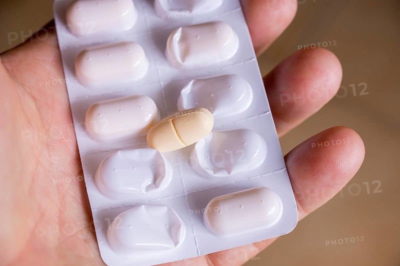 Hand holding a blister pack with a tablet