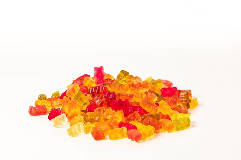 Group of different coloured gummy bears, on white, copying room