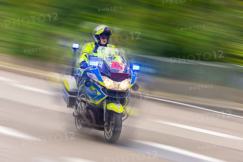 Police officer driving at high speed on a motorbike on a road with flashing blue lights, Stuttgart, Baden-Württemberg, Germany, Europe