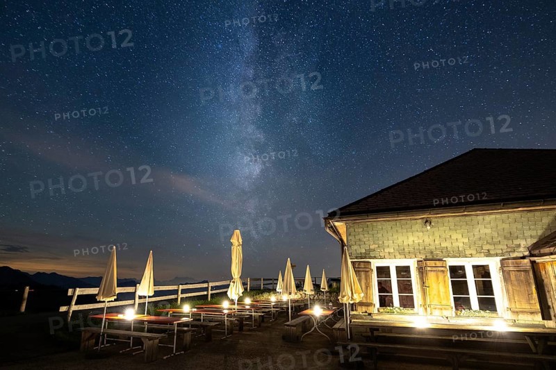 A mountain hut under a clear starry sky with the Milky Way visible and mountains in the background, Hochalp, Urnäsch, Appenzell Ausserrhoden, Switzerland, Europe