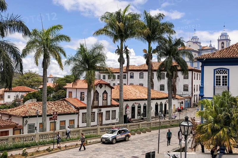 View to traditional houses and palm tree lined street in historic center of Diamantina on a sunny day, Minas Gerais, Brazil, South America