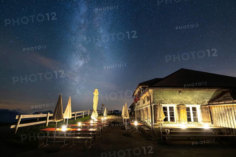 A mountain hut under a clear starry sky with the Milky Way visible and mountains in the background, Hochalp, Urnäsch, Appenzell Ausserrhoden, Switzerland, Europe