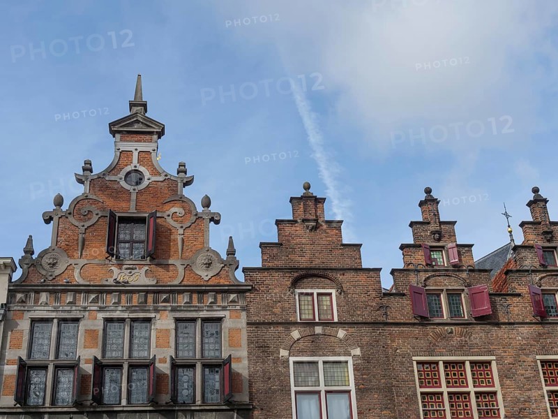 Historic brick buildings with ornate gables and red shutters against a blue sky, nijmegen, the netherlands