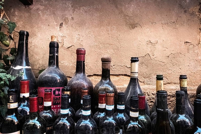 Old open red wine bottles dusted by time. Chianti, Brunello di Montalcino e Vino Nobile di Montepulciano, Cabernet Sauvignon, Merlot e Pinot Nero and Vernaccia