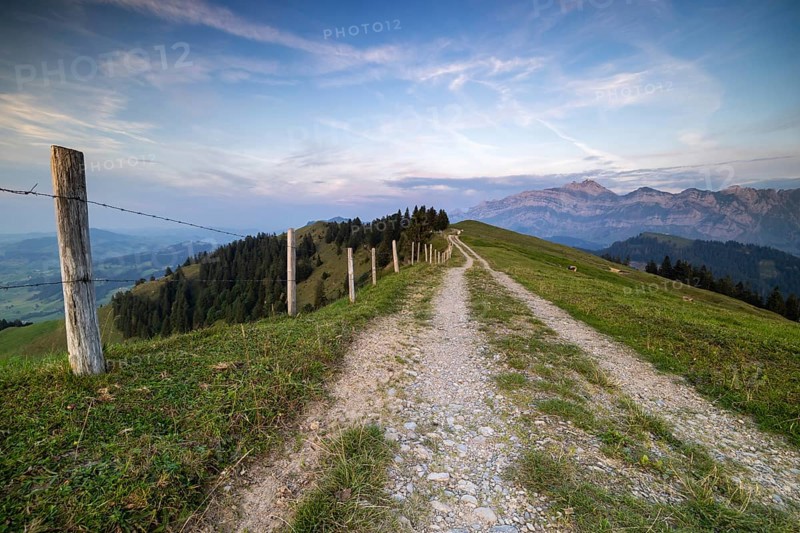 An impressive panorama of mountains with rocky peaks and dense forests under a cloudy sunset, Hochalp, Urnäsch, Appenzell Ausserrhoden, Switzerland, Europe