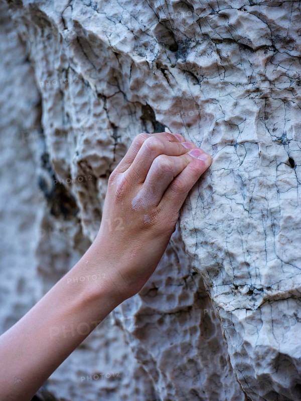 Close-up, hand of a climber grasping a small hold on the rock, Belove Stene climbing area, island of Krk, Croatia, Europe