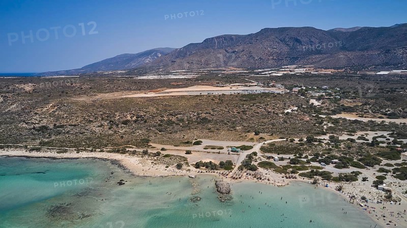 Overtourism, A beach with clear water, surrounded by a wide, dry landscape and mountains in the background, Elafonissi, lagoon, south-west tip of Crete, Crete, Greek Islands, Greece, Europe