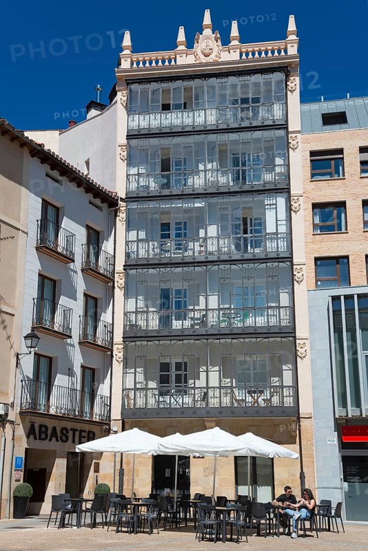 A modern building with balconies and an outdoor café, including tables and chairs under a clear blue sky, modernist house, modernism, Plaza Bernado Robles, Soria, Castilla y León, Leon, Spain, Europe