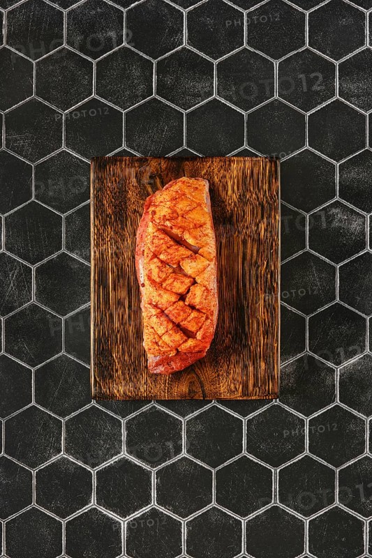 Top view of a spice rubbed duck breast on a wooden chopping board