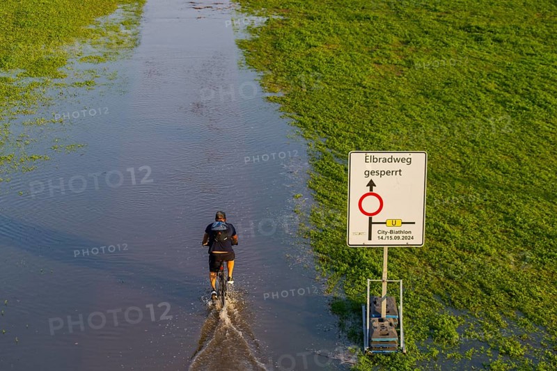 A weather-determining low-pressure system is moving from northern Italy on a so-called Vb track via Austria and the Czech Republic to Poland, bringing very humid air with it. This will also lead to flooding in the Elbe in Saxony. On 18.9.24, the level of the Elbe in Dresden is 6.06m. Cyclists on the Elbe cycle path, which is closed due to flooding, Elbe floods in Dresden, Dresden, Saxony, Germany, Europe