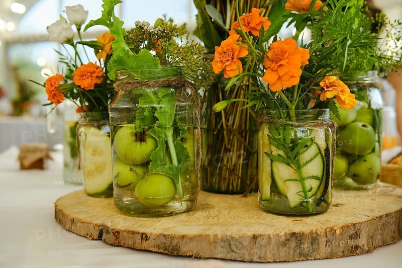 Concept of festive decoration of table, fruits and plants in jar with water