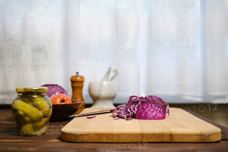 Red cabbage and ingredients for salad on kitchen table