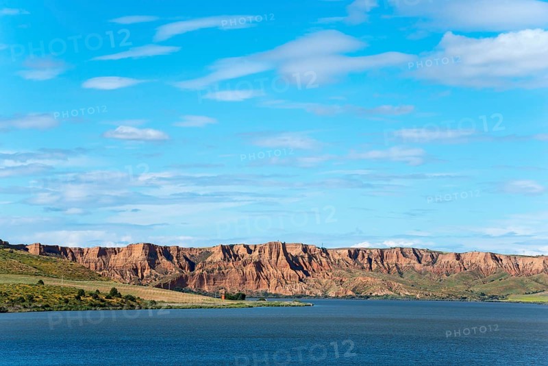 A clear blue lake surrounded by majestic rock formations and rolling hills under an expansive sky, Barrancas de Burujón, Burujon, río Tajo, river Tajo, embalse de Castrejón, reservoir de Castrejon, Toledo, Castilla La Mancha, Spain, Europe