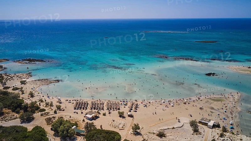 Overtourism, sandy beach with many parasols and people enjoying the clear blue sea. The sky is cloudless, Elafonissi, lagoon, south-west tip of Crete, Crete, Greek islands, Greece, Europe