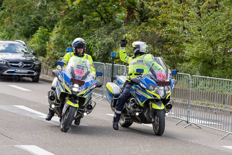 Two policemen on motorbikes in uniform on a street surrounded by security barriers and trees, Stuttgart, Baden-Württemberg, Germany, Europe