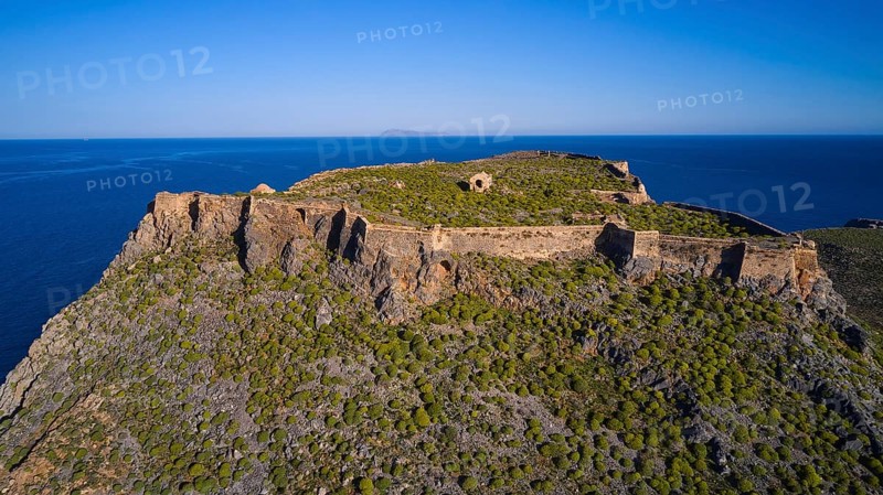 Drone shot, An old fortress perched on a green, rocky hill with sweeping sea views and surrounding cliffs, Venetian sea fortress, Gramvoussa, Gramvoussa Peninsula, Pirate Bay, Balos, Lagoon, Northwest Crete, Crete, Greek Islands, Greece, Europe