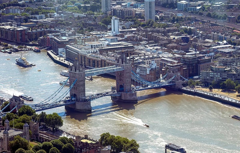 Aerial view of Tower Bridge over the river, surrounded by city buildings and boats, London, United Kingdom, Europe