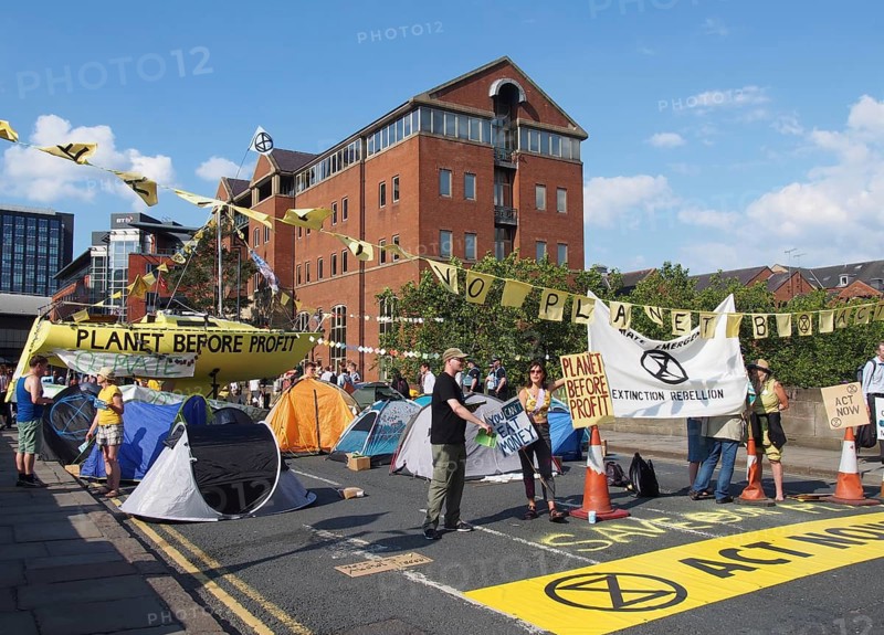 Leeds, west yorkshire, united kingdom, 16 july 2019: extinction rebellion protesters blocking thee road at victoria bridge in leeds west yorkshire holding signs and banners
