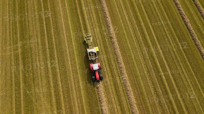 A tractor with a straw baler in a field