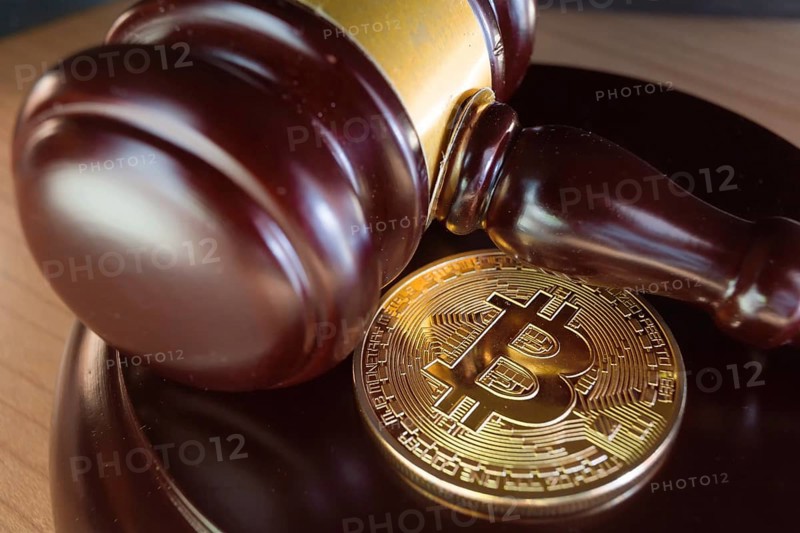 Bitcoin regulation. BTC cryptocurrency coin and judge gavel on a desk. Banned currency or law enforcement concept