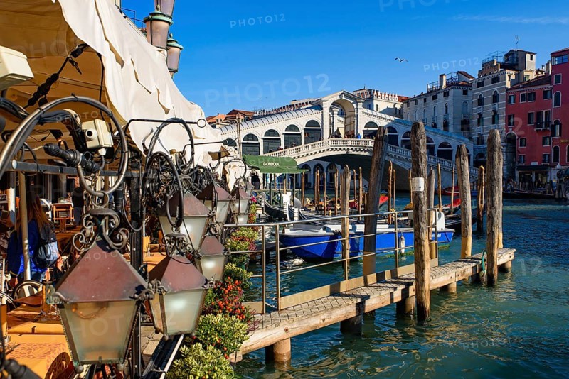 View of the Grand Canal, Rialto Bridge, and gondolas from outdoor restaurant seats, Venice, Italy, Europe