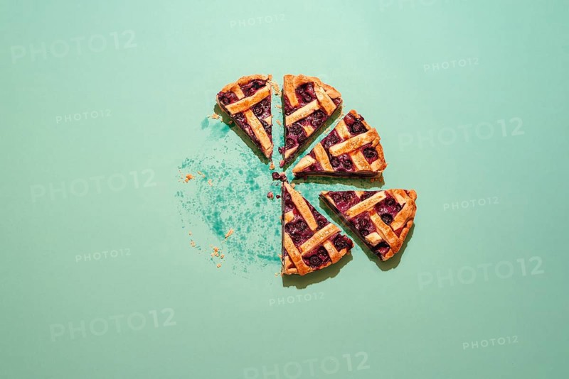 Homemade blueberry cake top view. Slices of delicious blueberries pie on a green table. Fruits tart with lattice crust