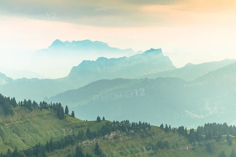 An impressive panorama of mountains with rocky peaks and dense forests under a cloudy sunset, Hochalp, Urnäsch, Appenzell Ausserrhoden, Switzerland, Europe