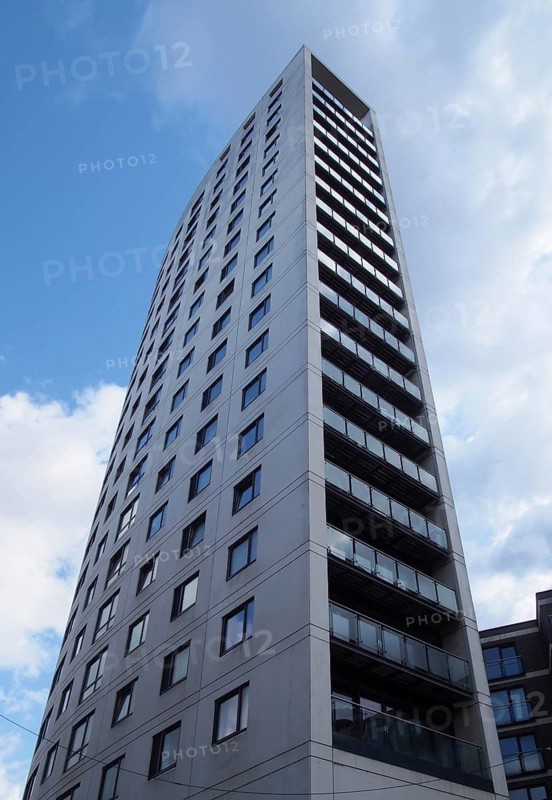 Leeds, west yorkshire, united kingdom, 16 july 2019: clarence house a 218 foot tall modern apartment and retail building in the leeds dock area against a blue cloudy sky