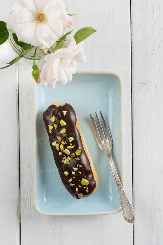 Eclair with chocolate ganache with pistachio topping