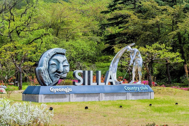 Silla Gyeongju Country Club sign with artistic sculptures, surrounded by lush greenery and trees in a spring setting in Gyeongju, South Korea, Asia