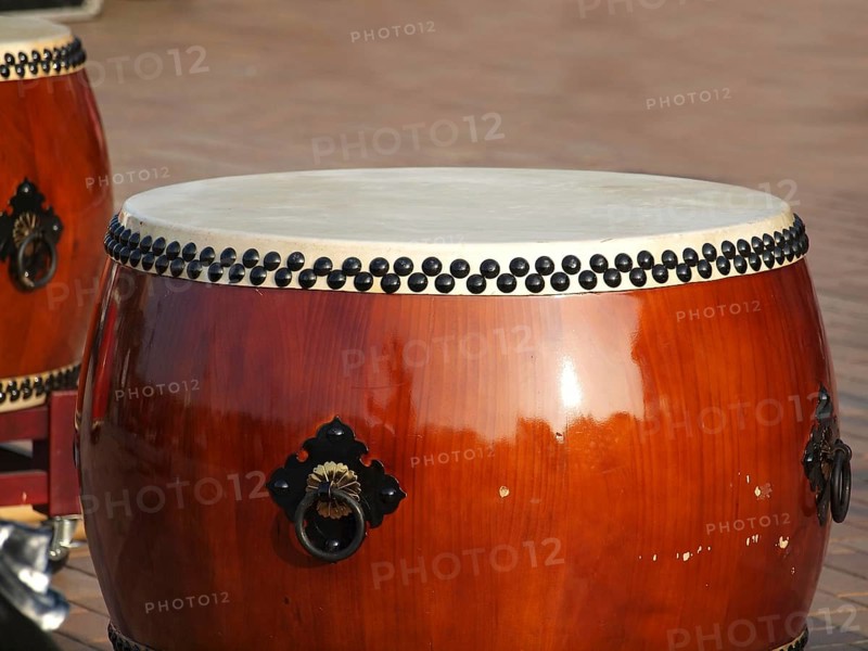 Two large traditional Chinese drums with brass handles and black tacks