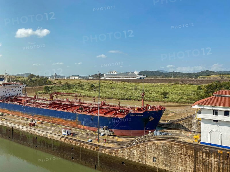 Large cargo ship in a canal with locks and industrial environment, panama city, panamakanl, panama, Central America