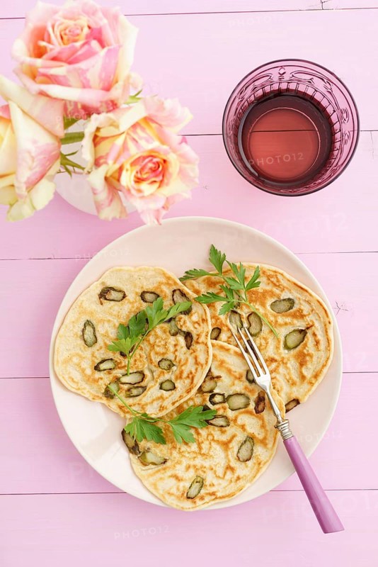 Pancakes with purple asparagus on a pink plate with roses