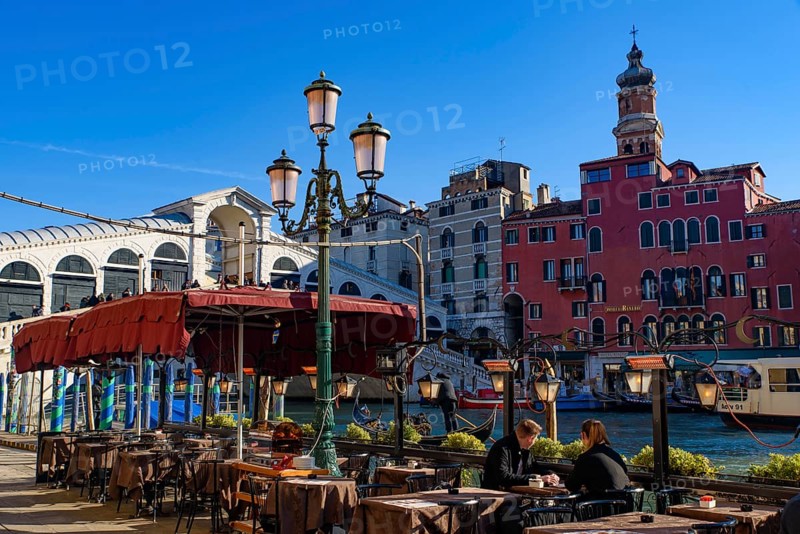 View of the Grand Canal, Rialto Bridge, and gondolas from outdoor restaurant seats, Venice, Italy, Europe