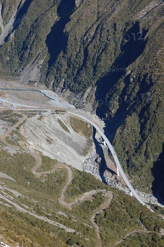 Otira Viaduct at Arthur's Pass, West Coast, South Island, New Zealand. Old road winds up the hill at the left. Scenic lookout at bend of road at top