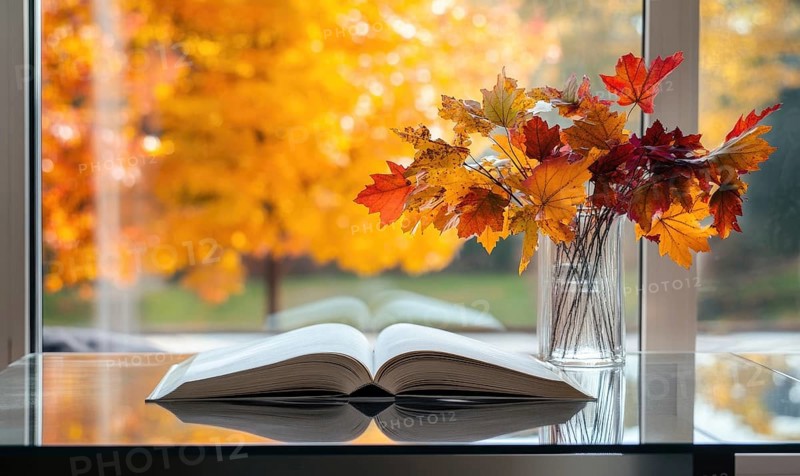 Minimalist table with a couple of books and a vase filled with vibrant autumn leaves AI generated