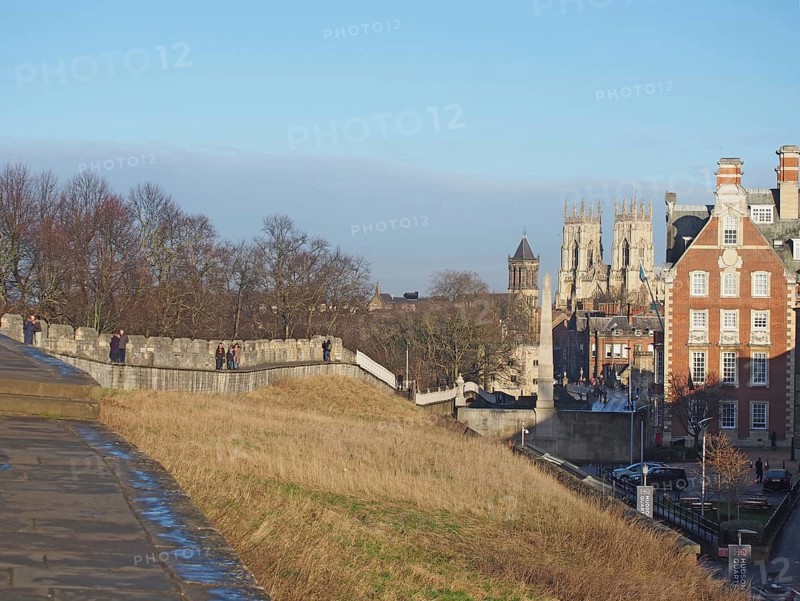 York, north yorkshire, united kingdom, 22 January 2020: people walking along the city walls in york with the minster and buildings of the city in the distance