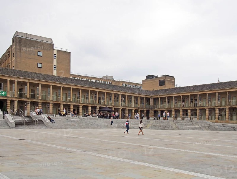 Halifax, west yorkshire, united kingdom, 12 july 2019: people walking and sat on the steps of the piece hall in halifax west yorkshire