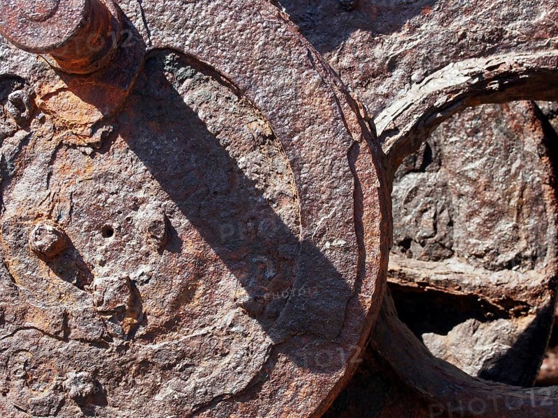 Corroded iron wheels covered in brown rust on old industrial machinery