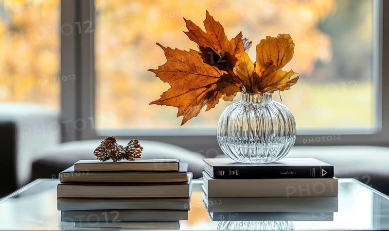 Minimalist table with a couple of books and a vase filled with vibrant autumn leaves AI generated