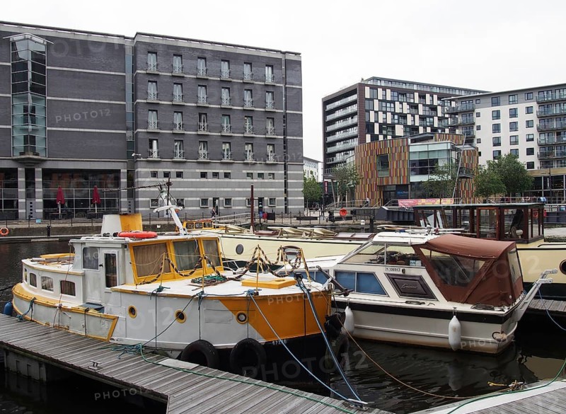 Leeds, west yorkshire, united kingdom, 1 july 2019: boats moored on the jetty at leeds dock with surrounding apartment buildings