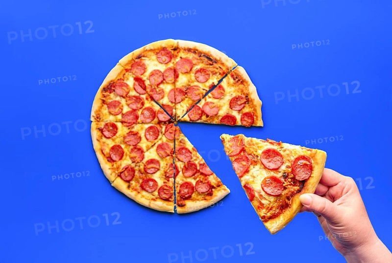 Woman's hand taking a slice of pizza, above view. Delicious pepperoni pizza isolated on a blue background