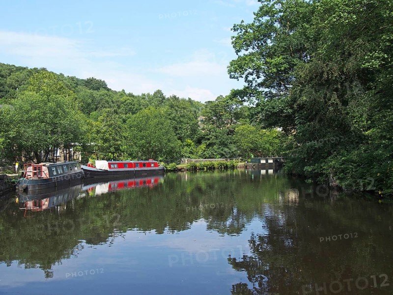 Traditional barges moored on the rochdale canal surrounded by calder valley countryside near hebden bridge west yorkshire