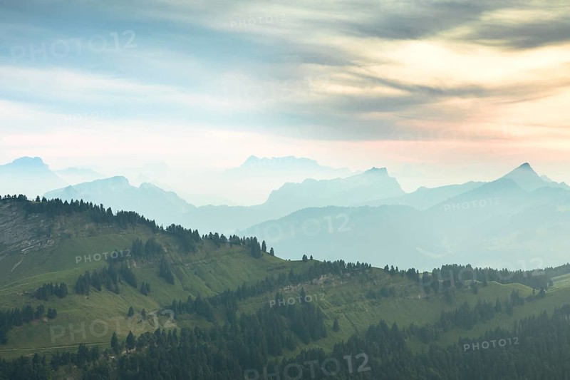 An impressive panorama of mountains with rocky peaks and dense forests under a cloudy sunset, Hochalp, Urnäsch, Appenzell Ausserrhoden, Switzerland, Europe
