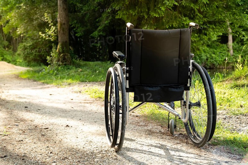 Photo of empty wheelchair parked in park, health care concept