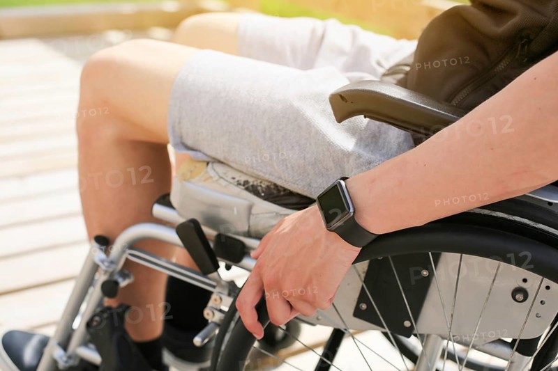 Disabled young athletic man on a wheelchair holding and turning wheels with hand engage in sports