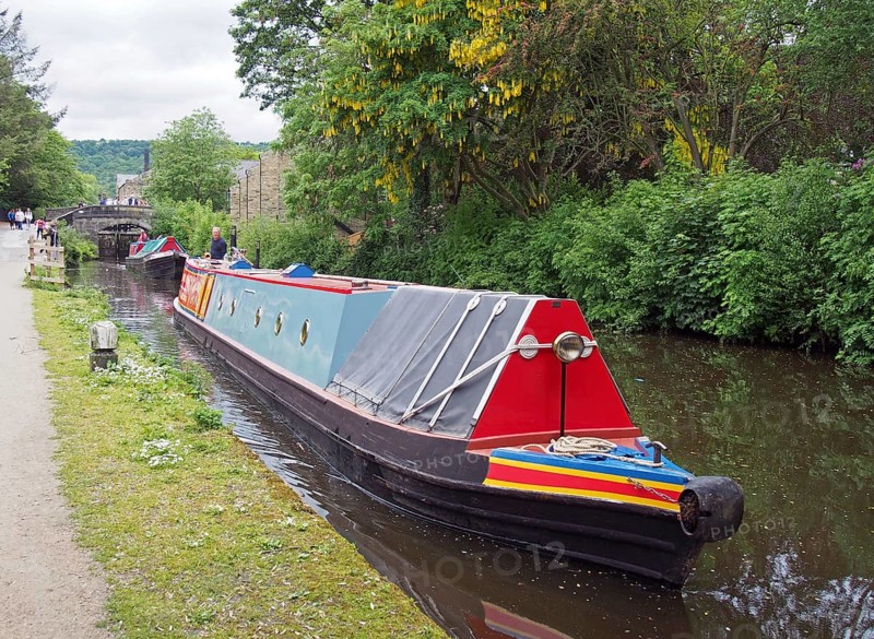 Hebden, west yorkshire, united kingdom, 28 may 2019: vintage canal boats passing though black pit lock in hebden bridge west yorkshire with people watching from the towpath