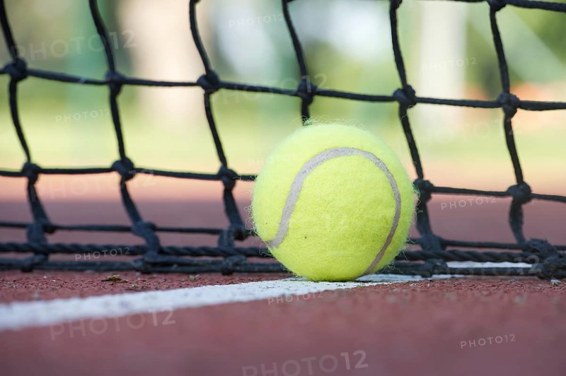 Tennis scene with black net, ball on white line in low angle view